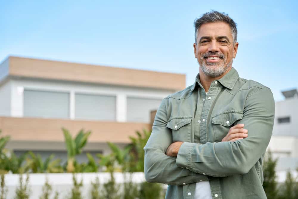 Man standing outdoors with his arms folded