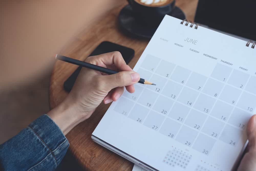 Planning ahead in June with a calendar, pencil in hand, and a coffee nearby.