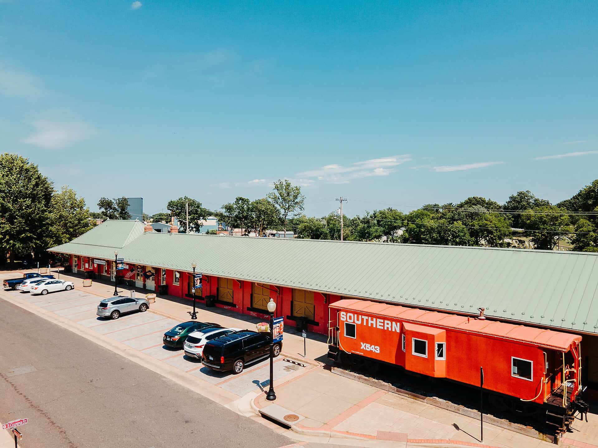 Red train depot and caboose under a blue sky at the Culpeper Train Depot and Visitor Center.