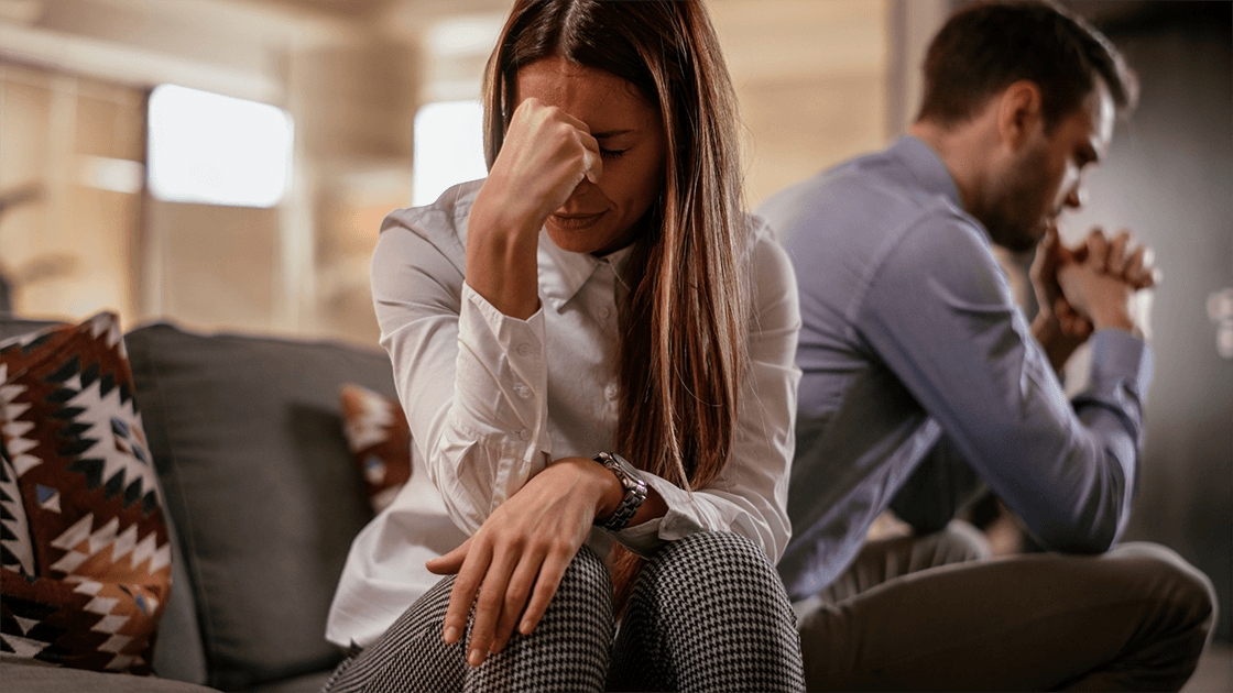 Two parents in a mediation session with a neutral third-party mediator, discussing child custody.