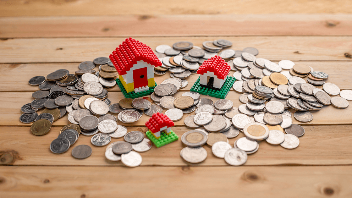 Lego homes surrounded by coins representing separating and protecting assets during a divorce.