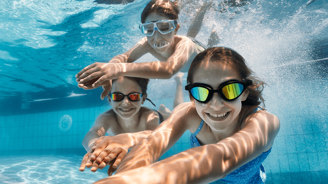 Children playing in pool smiling between two homes, representing summer custody transition.