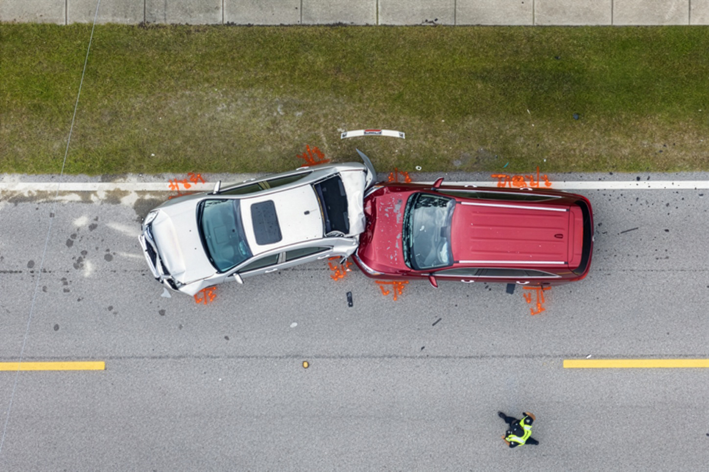 Aerial view of a car accident with police officer at the scene.