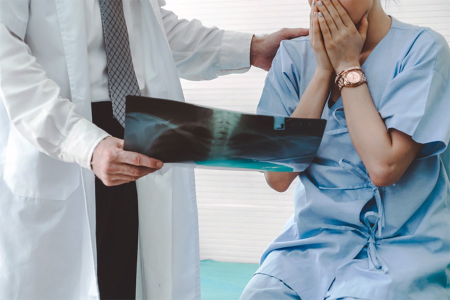 Doctor showing X-ray to patient in hospital setting.