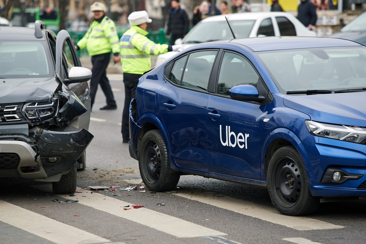 Uber car involved in accident with police and emergency responders present.