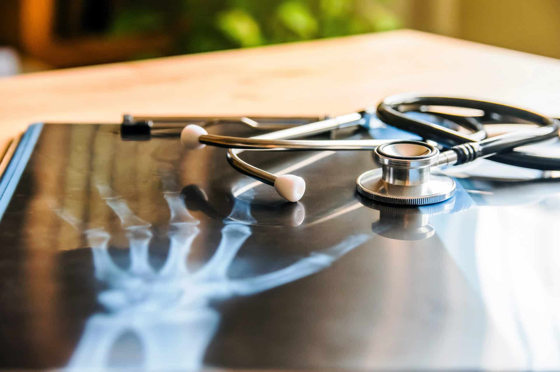 X-ray image with stethoscope on a wooden table for healthcare.