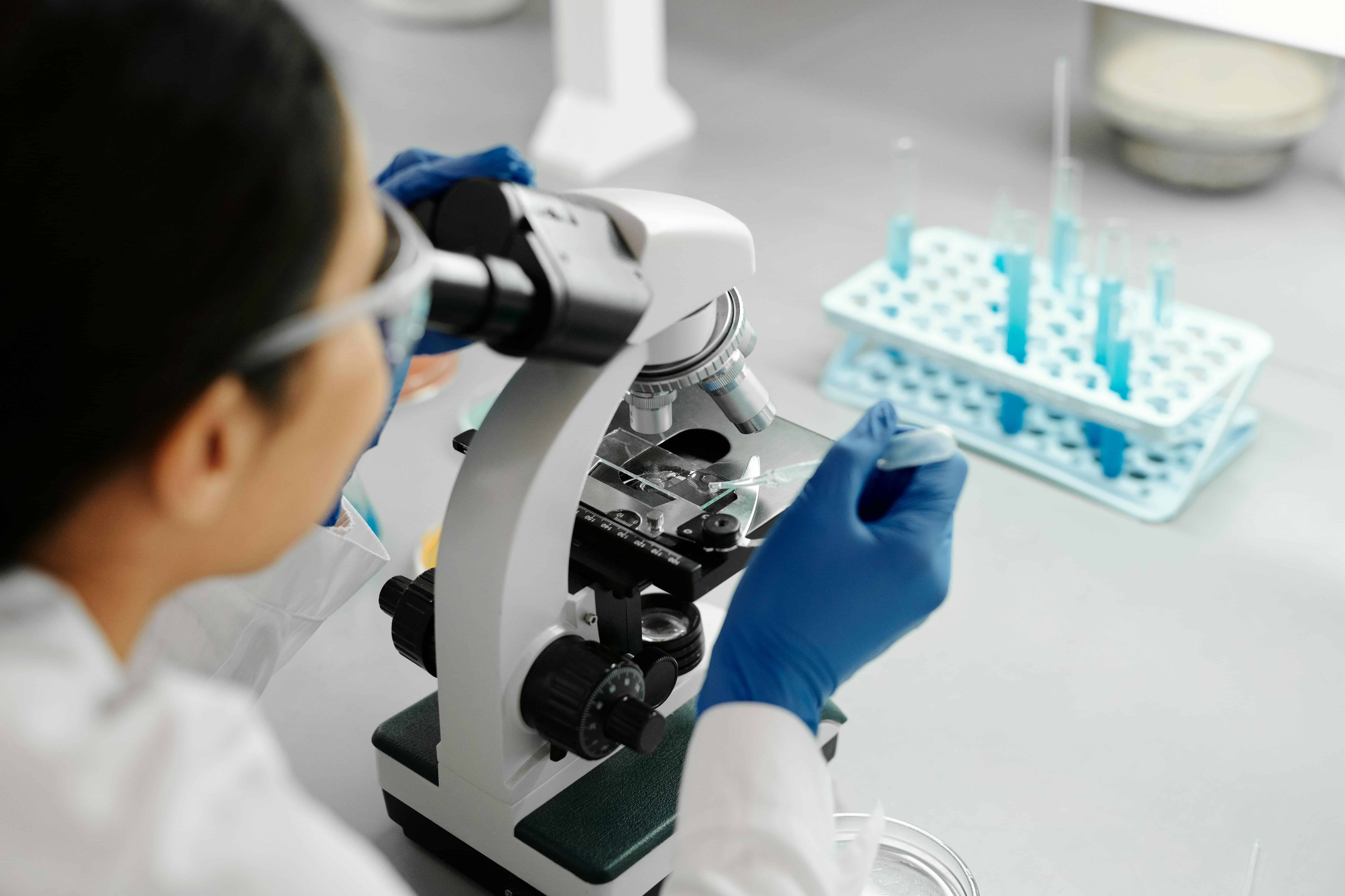 Onderzoeker met microscoop in laboratorium voor ontwikkelingsachterstand.