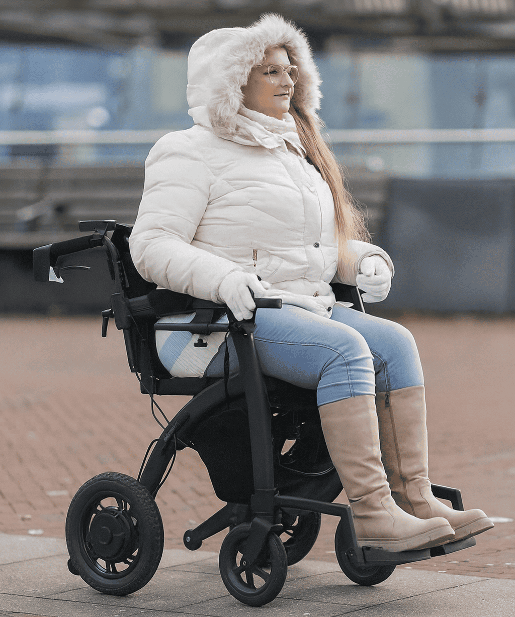 Vrouw in rolstoel met winterjas en laarzen buiten.
