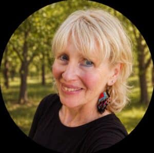 Smiling woman with blonde hair standing in front of an orchard. She has a black shirt and a native styled ear ring. Lisa Shatsky External Clinical Supervisor