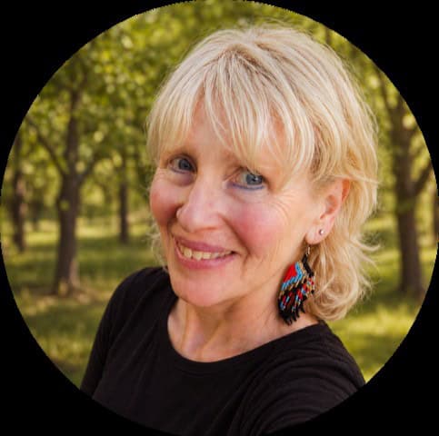 Smiling woman with blonde hair standing in front of an orchard. She has a black shirt and a native styled ear ring. Lisa Shatsky External Clinical Supervisor