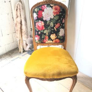 Antieke stoel met fleurige stoffering en geel velvet zitting.