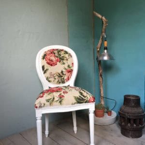 Unieke vintage stoel met bloemendecoratie, past perfect in een retro interieur.