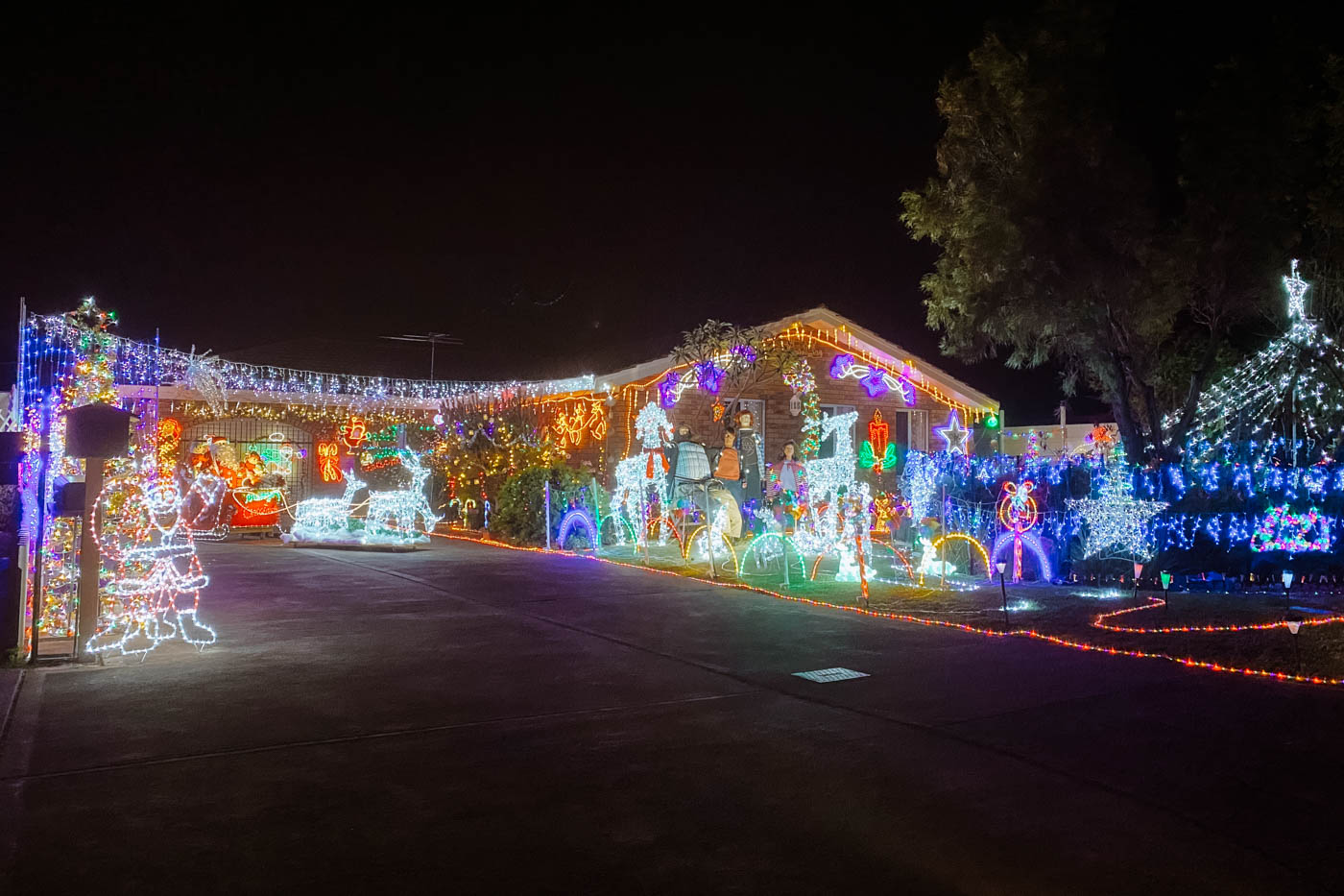 House and front yard fully decorated with amazing Christmas lights, reindeers, Santa and elves