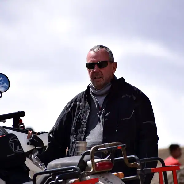 Rider David S. on his motorcycle under a mountain sky — motorbike adventure holidays, Outriders Co.