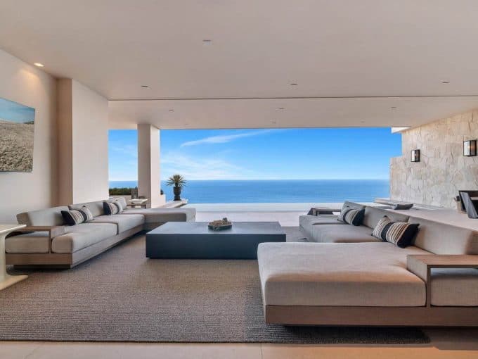 Luxurious Open-Concept Living Room At Palmilla With Modern Beige Sofas, Ocean Views, And Stylish Decor, Offering An Elegant And Relaxing Coastal Lifestyle.