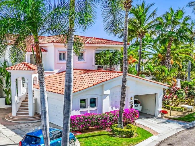 1. Palmilla Luxury Home With White Walls, Terracotta Roof, Surrounded By Lush Palm Trees And Vibrant Gardens, Located In A Beautiful Coastal Community.