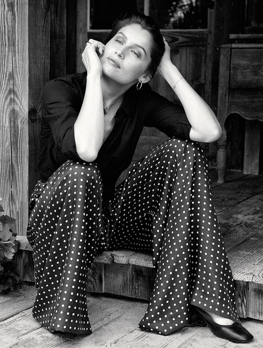 Elegant black and white portrait of a woman with polka dot wide-leg pants, showcasing professional fashion photography by Pamela Hanson, captured outdoors in natural light.