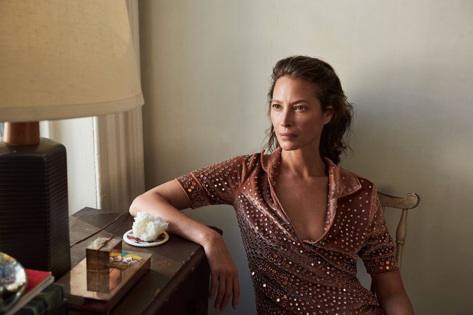 Elegant woman photographing in natural light, wearing a shimmering bronze dress with rhinestones, lifestyle portrait photography by Pamela Hanson.