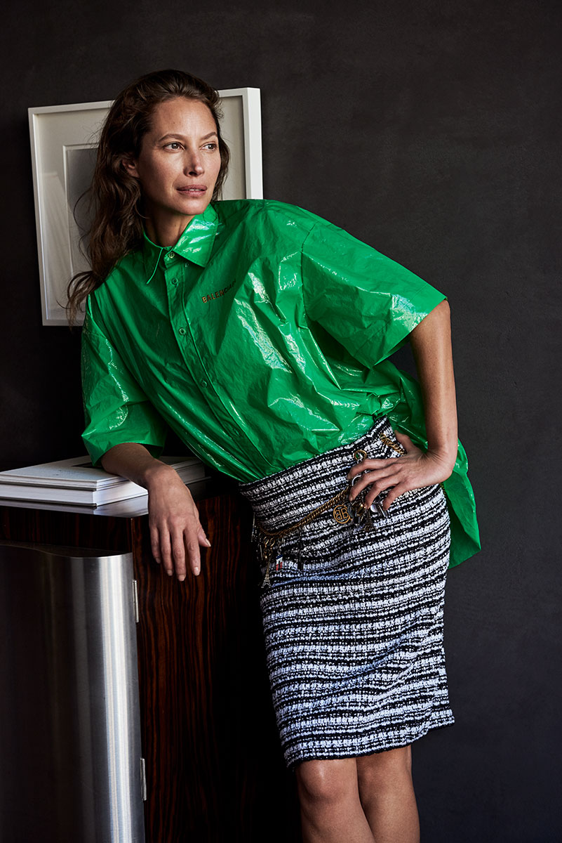 Vibrant green Balenciaga shiny shirt paired with a textured black-and-white tweed skirt in a fashion-forward photoshoot; elegant yet modern look.