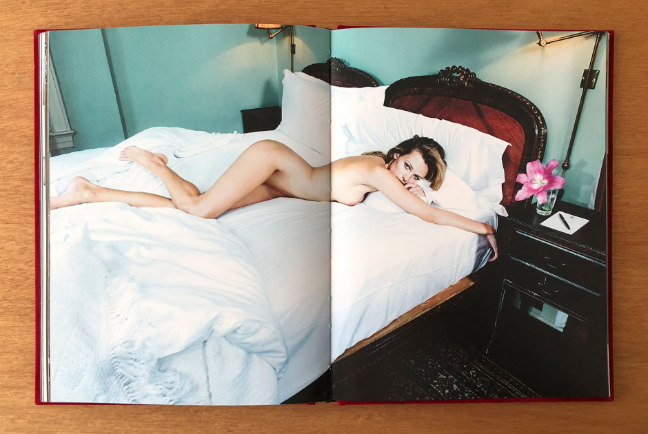 Erotic nude woman lying on bed with vintage headboard, stylish bedroom setting, artistic high-quality photography for fine art nudes, sensual and elegant imagery.
