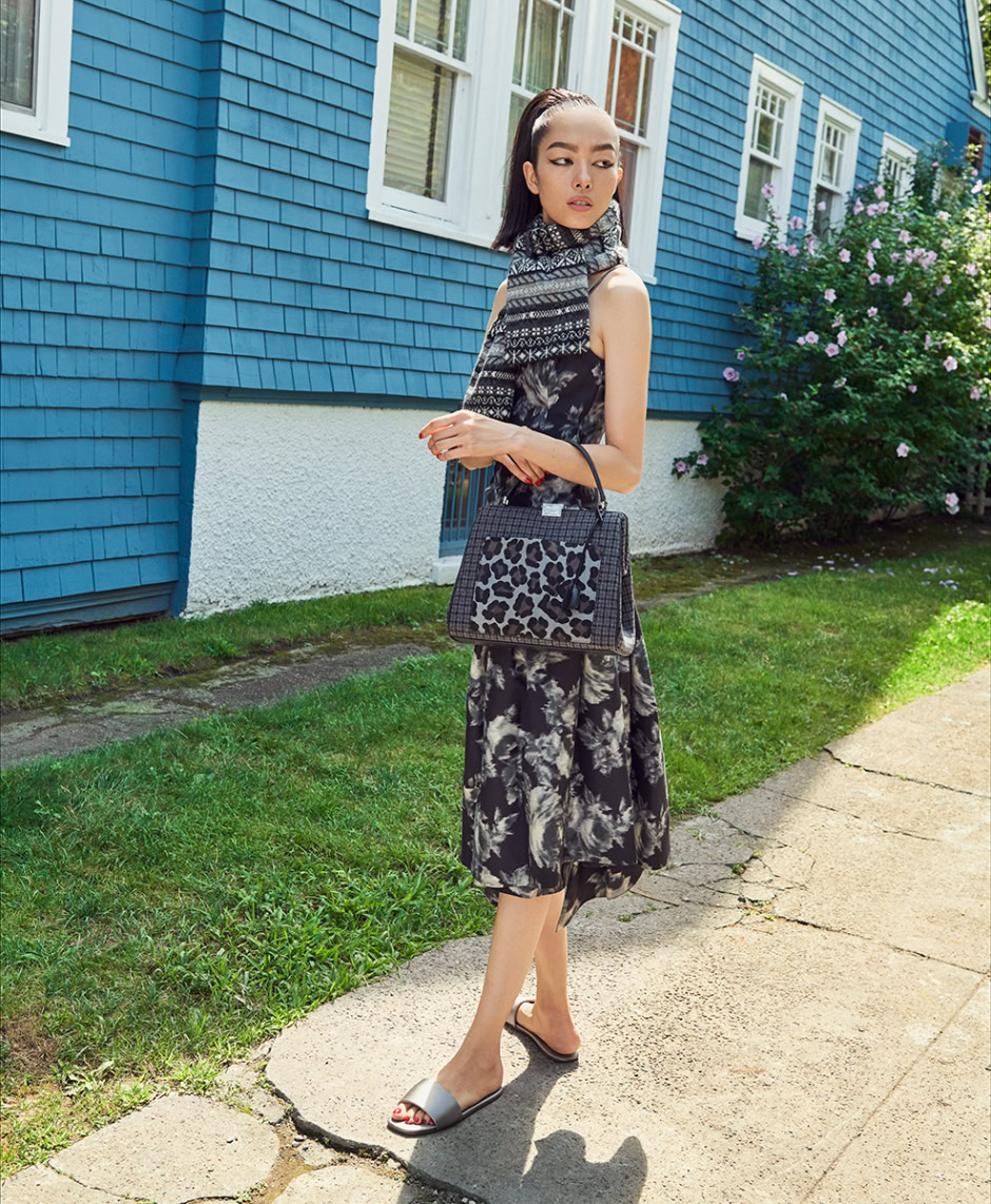 Elegant fashionista wearing black and white floral and animal print dress, accessorized with leopard print handbag, outdoor summer shot by Pamela Hanson Photography.