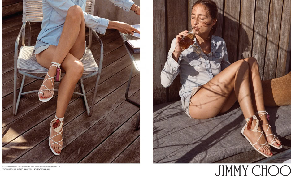 White lace-up summer sandals with tassels and ankle ties on a woman sitting outdoors in a relaxed pose.