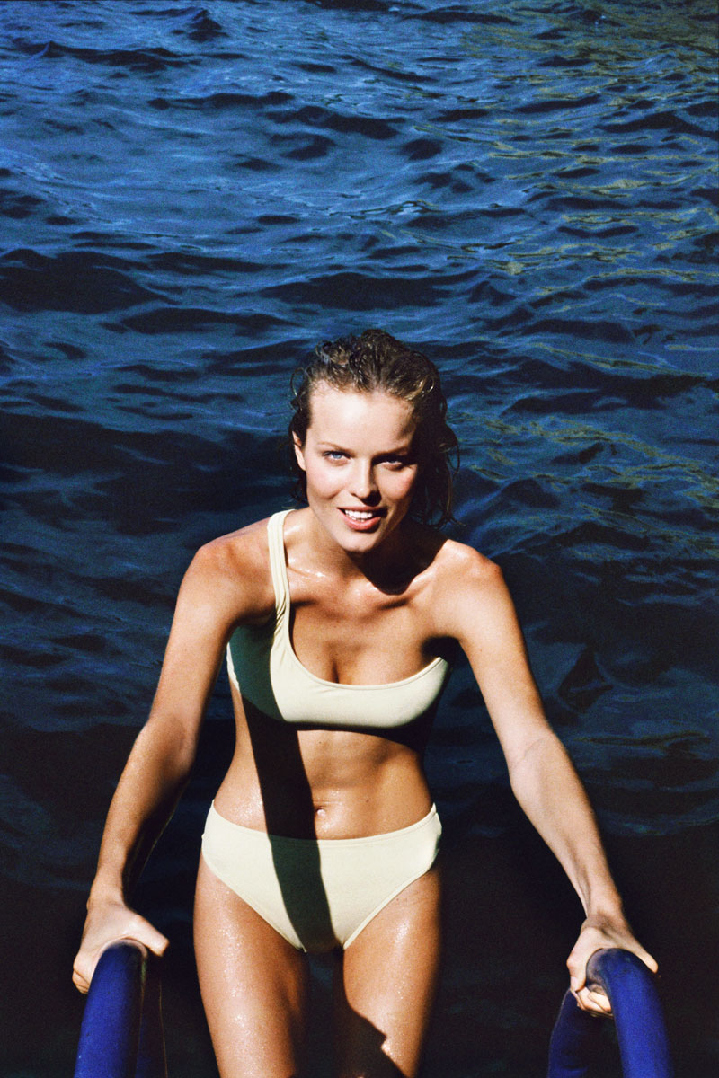 Swimming woman in a swimsuit emerging from the water at the beach, showcasing natural beauty and vibrant outdoor scenery, captured by Pamela Hanson Photography for a captivating summer photoshoot.