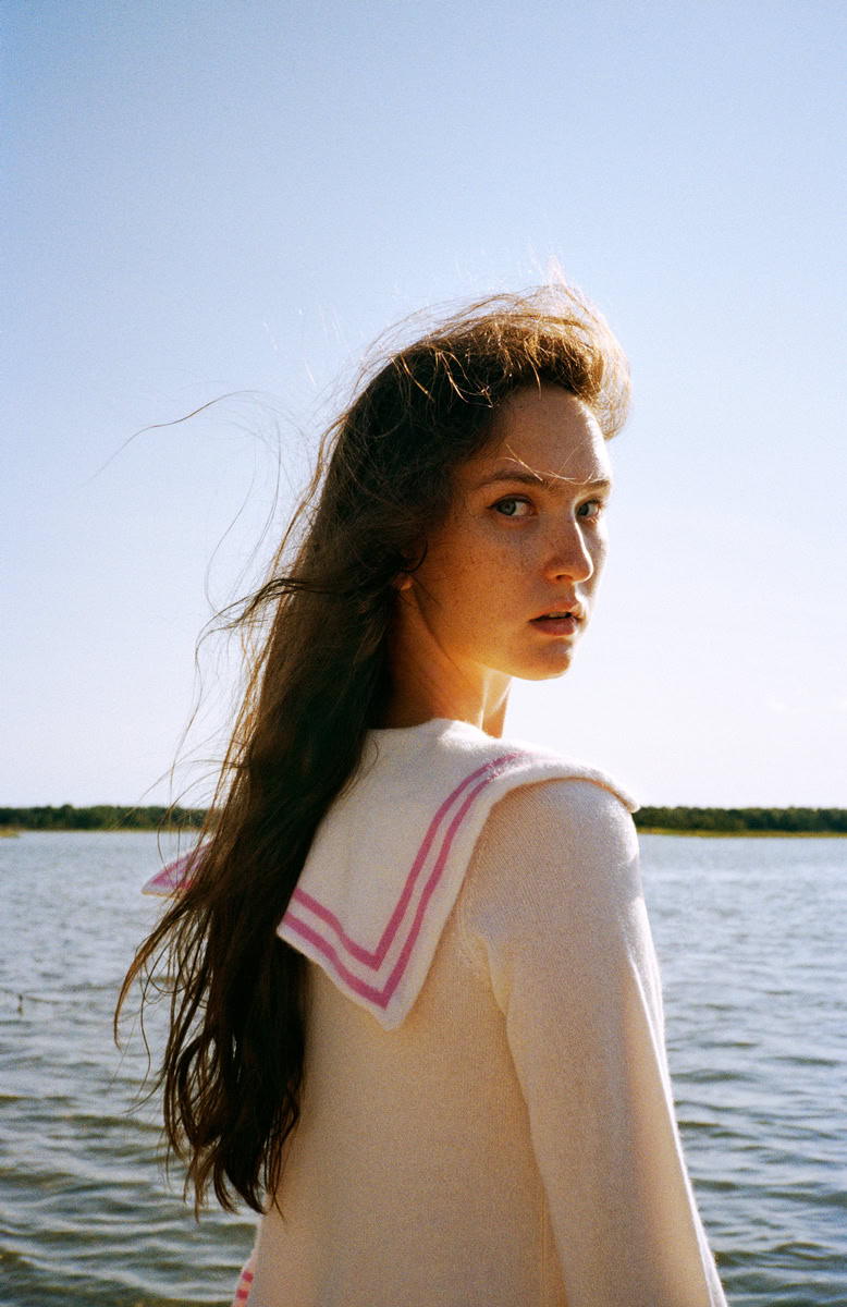 Elegant portrait of a young woman by Pamela Hanson Photography at scenic waterfront location, showcasing professional fashion and beauty photography with natural lighting and stunning ocean backdrop.