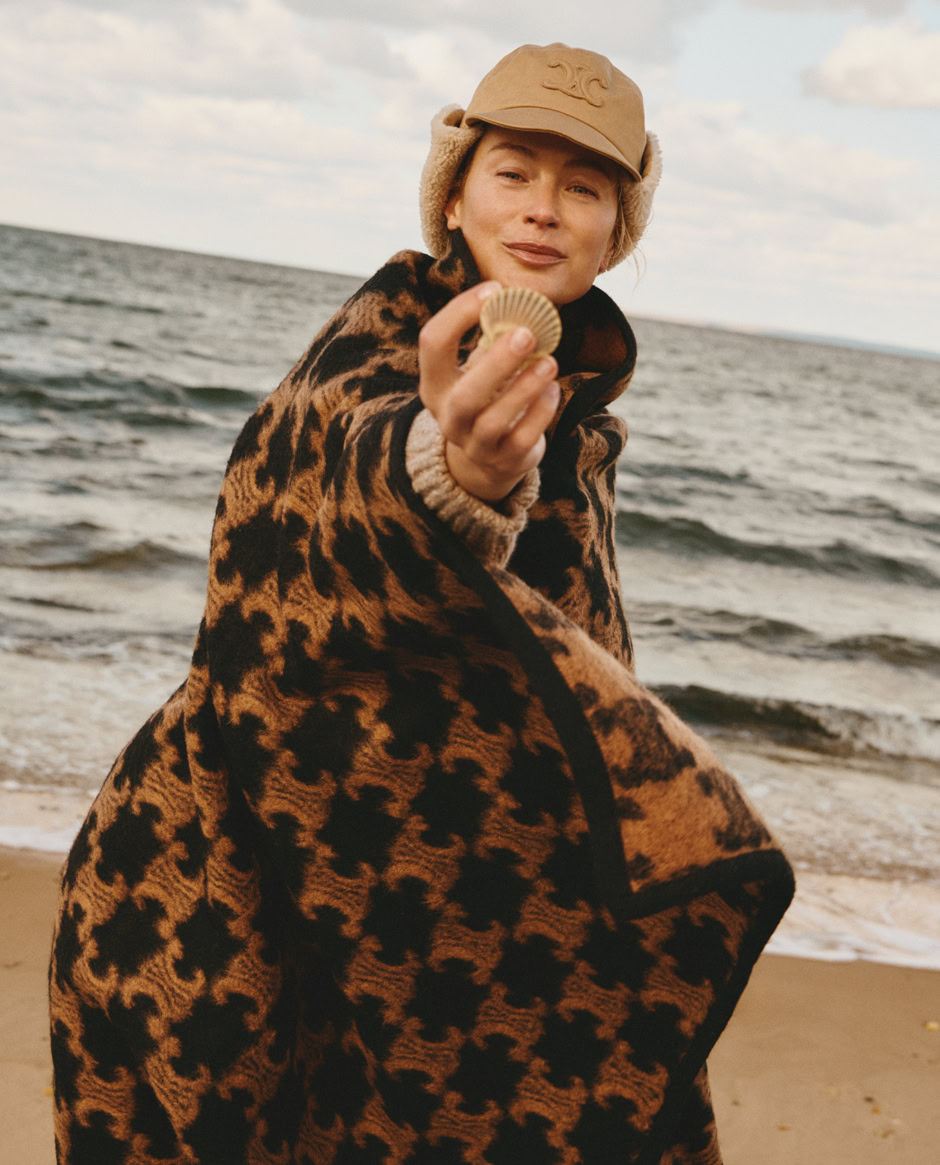 Golden-hour portrait of a woman on the beach holding a seashell, showcasing natural light photography, fashion, and seaside scenery, emphasizing elegant portrait photography by Pamela Hanson.