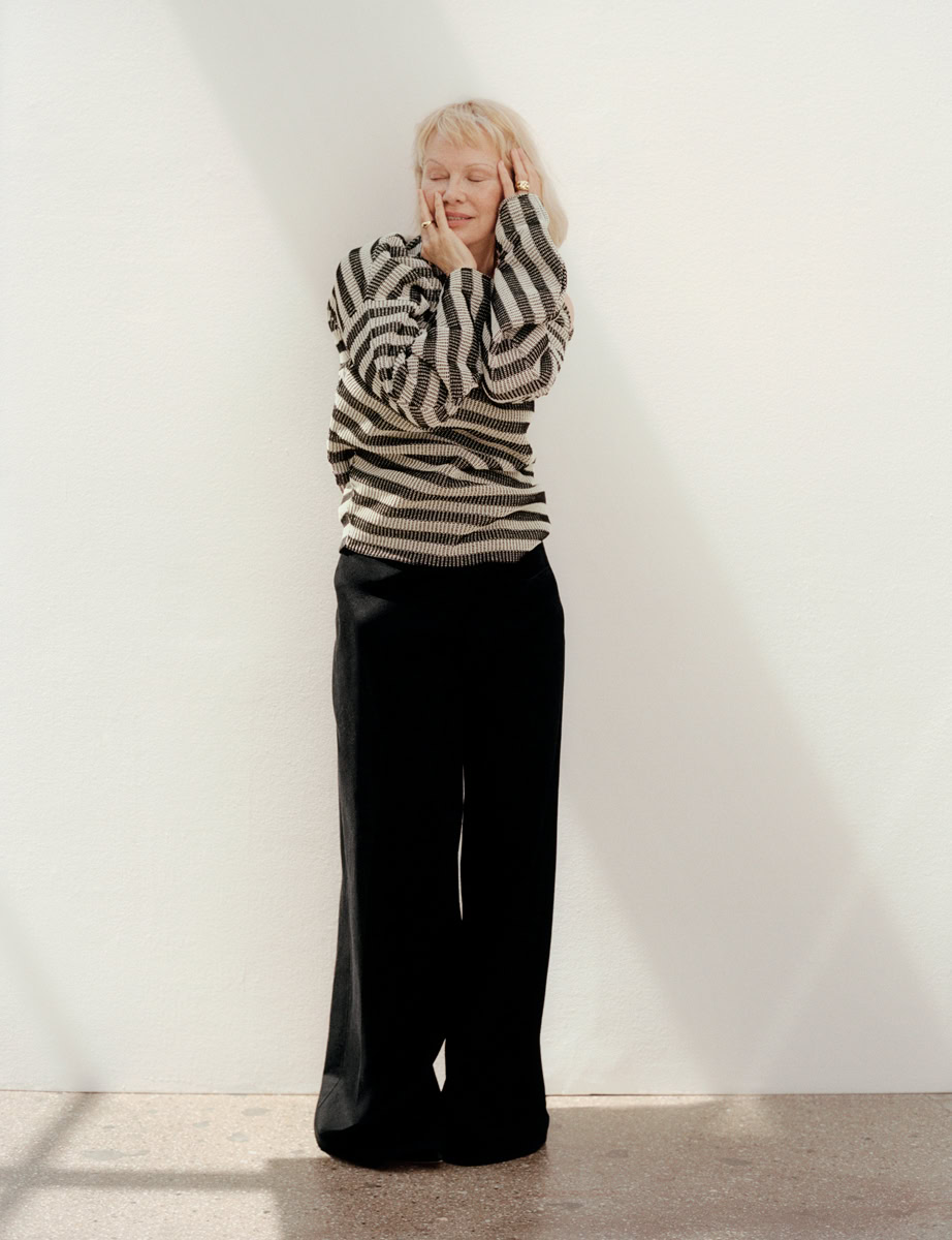 Elegant woman portrait showcasing fashion photography by Pamela Hanson, featuring stylish black wide-leg trousers and a patterned sweater, perfect for editorial and professional portfolio images.