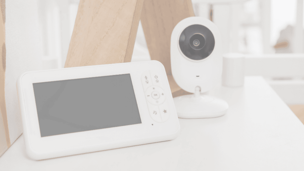 A white video baby monitor screen and camera on a table