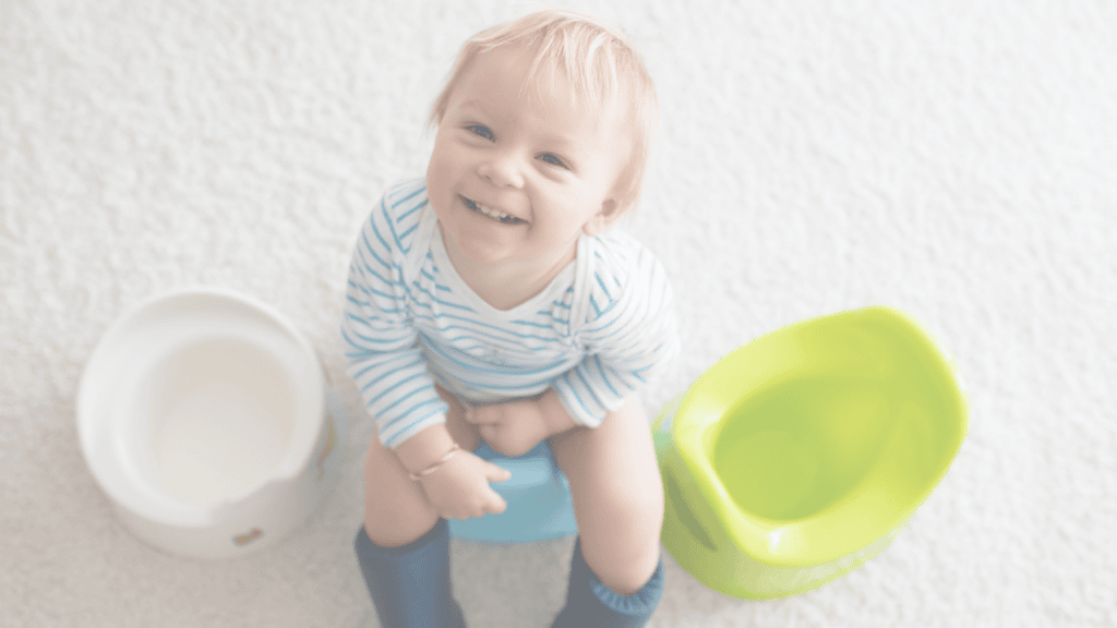 A smiling toddler sitting on a potty, seen from above