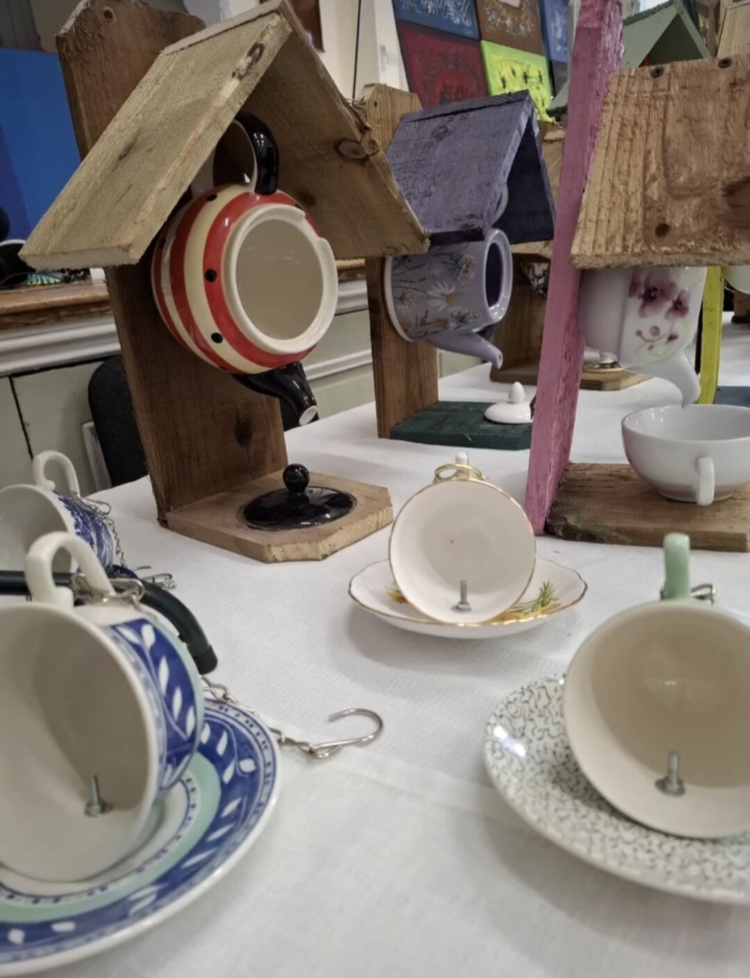 Upcycled wooden bird feeders with cups and hooks for garden birds.