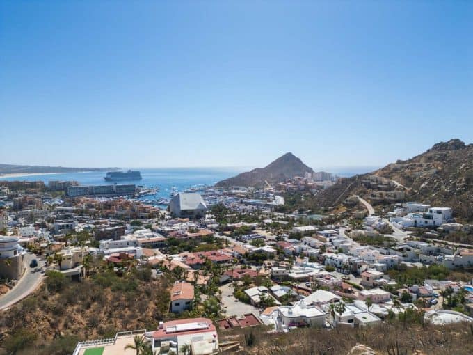 Vibrant Aerial View Of Pedregal Showcasing Luxurious Homes, Scenic Hills, And The Sparkling Marina In The Distance, Highlighting The Exclusive Neighborhood And Stunning Coastal Landscape.