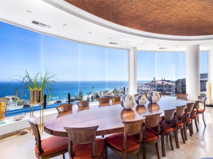 Luxury Pedregal Estate Dining Room With Panoramic Ocean Views And Modern Decor. Elegant Wooden Table With Ceramic Art Pieces, Perfect For Entertaining In A High-End Coastal Property.
