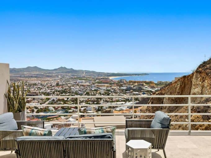 Panoramic View From Pedregal Property Showcasing The Cityscape And Ocean In The Distance, With Outdoor Seating And Mountain Terrain.