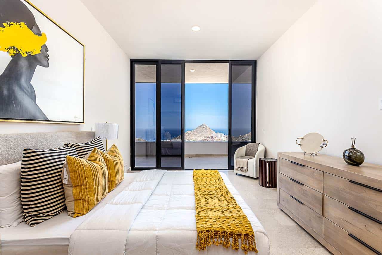Luxurious Pedregal Bedroom With Modern Decor, Overlooking Breathtaking Mountain And City Views Through Large Glass Doors, Featuring Stylish Furniture And Vibrant Accents.