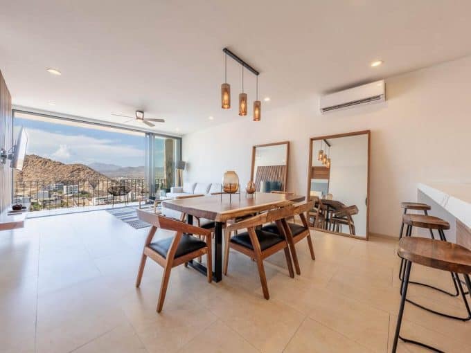 Contemporary Pedregal Apartment With Open Living Space, Modern Furniture, And Stunning Mountain Views Through Large Glass Doors. Stylish Decor And Natural Light Highlight Luxury Living.