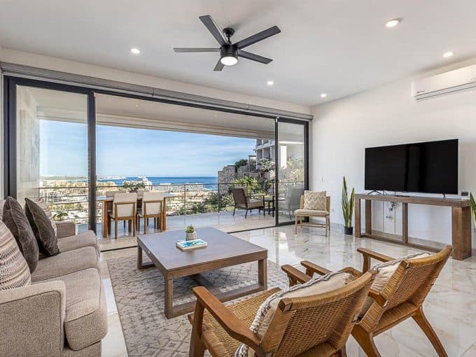 Pedregal Ocean View Hillside Living Room With Modern Decor And Large Glass Doors.