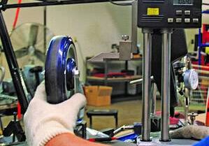 Digital caliper measuring caster wheel diameter for quality control.