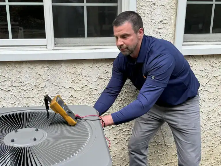 A man is outside a building, skillfully using a multimeter tool for high-velocity air conditioning repair on the unit.