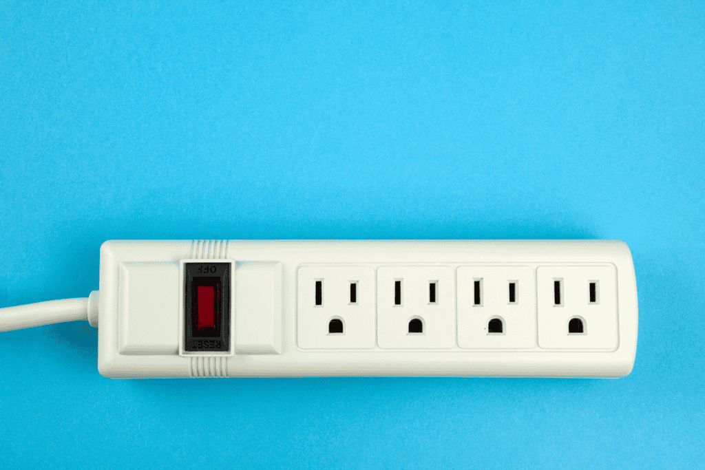 White surge protector with four outlets and a red reset switch on a blue background.