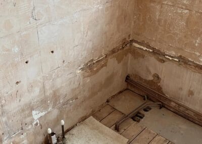 Bathroom renovation with exposed pipes and unfinished walls.
