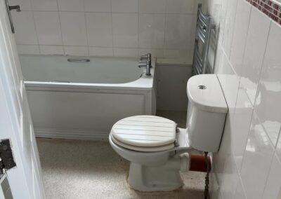 Compact bathroom with bathtub and toilet.