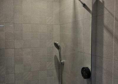 Modern shower head in tiled bathroom.