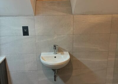 Modern bathroom with sink, toilet, and window.
