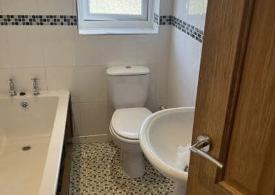 Small bathroom with bathtub, sink, and toilet.