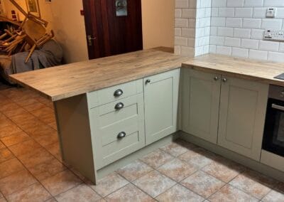 Modern kitchen with wooden countertop and tiled floors.