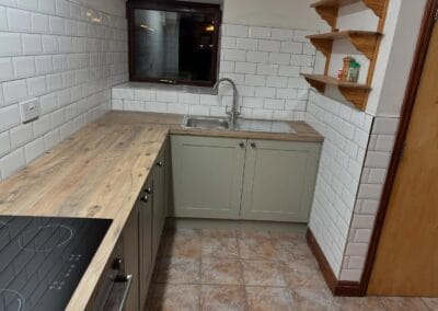 Modern kitchen with wooden countertops and tile backsplash.