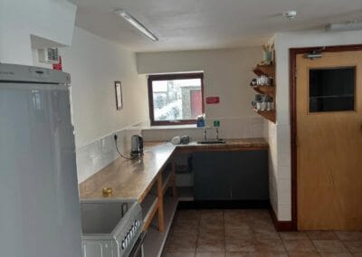 Simple kitchen with appliances and wooden shelves